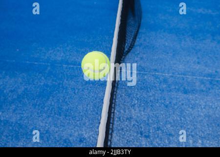 una palla in aria sulla rete di un campo da paddle tennis Foto Stock