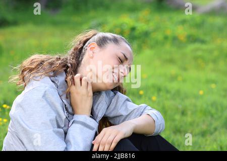 Escursionista graffiare il collo prurito lamentando dopo il morso di insetti nella montagna Foto Stock