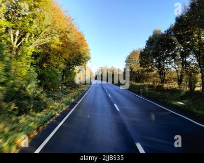 A straight highway with trees on the side Foto Stock