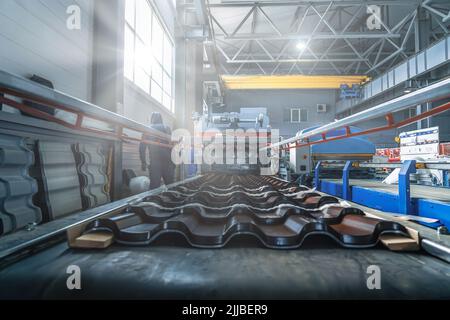 Tegole metalliche in acciaio zincato e verniciato in lamiera in fabbrica. Foto Stock