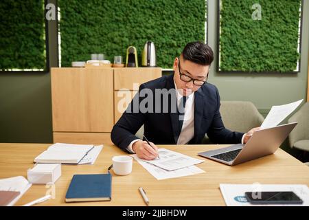 Vista frontale ritratto di un bel uomo d'affari asiatico che lavora in sala conferenze con eco design verde, spazio copia Foto Stock