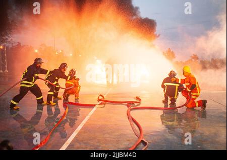 PICHIT , THAILANDIA - AGOSTO 29 , 2020 : un vigile del fuoco asiatico non identificato salva i loro compagni di squadra da una scottatura. Che è una pratica regolare di competenza Foto Stock