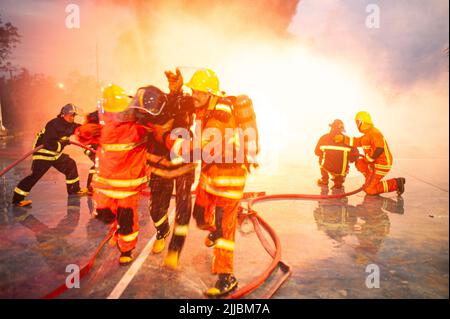 PICHIT , THAILANDIA - AGOSTO 29 , 2020 : un vigile del fuoco asiatico non identificato salva i loro compagni di squadra da una scottatura. Che è una pratica regolare di competenza Foto Stock