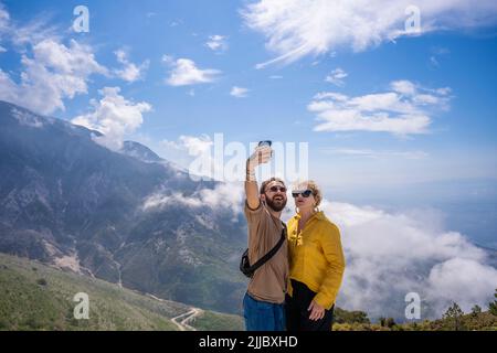 Felice escursionismo coppia tenendo selfie insieme sulla cima della montagna Foto Stock