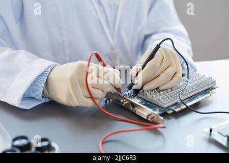 Primo piano di un tecnico di laboratorio che controlla i componenti hardware presso la stazione di controllo qualità, spazio di copia Foto Stock