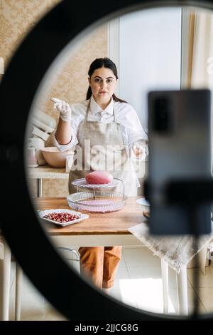 Side Hustle Ideas to Make Money, cucina online corsi. Asian Arabic donna pasticceria chef Foto Stock