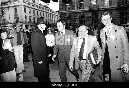 Il primo ministro neozelandese Robert Muldoon è accompagnato da poliziotti inglesi di abbigliamento semplice come lui passa i manifestanti all'arrivo a Lancaster House, Londra, mercoledì 8 1977 giugno. Muldoon si è recato a Londra per partecipare alla Conferenza dei leader del Commonwealth, dove i leader di 35 paesi si sono incontrati a Lancaster House a Londra. Credit: Rob Taggart/Alamy Foto Stock