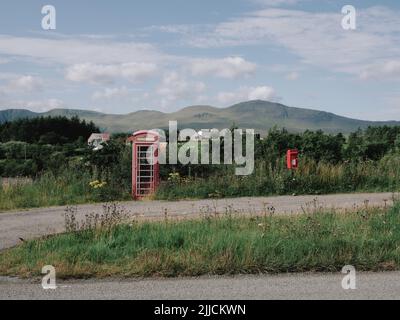 Una scatola telefonica rossa e una casella postale Royal Mail nel remoto paesaggio isolato della penisola di Trotternish, Isola di Skye, West Highlands, Scozia Regno Unito Foto Stock