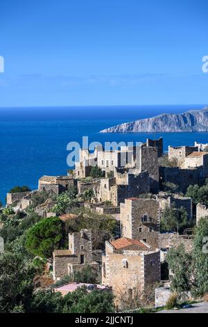 Le torri di pietra e le case in rovina di Vathia con la costa drammatica del mani profondo sullo sfondo, peloponneso meridionale, Grecia. Foto Stock