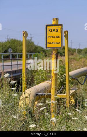 Segnale di avvertimento giallo della tubazione del gas ad alta pressione Foto Stock