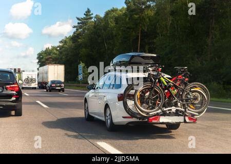 Guida auto lungo l'autostrada con il portabagagli per tetto & top box  dotato di moto anche con posteriore montato in rack di ciclo (oscurato  targhe di immatricolazione Foto stock - Alamy