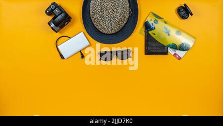 Accessori da viaggio su sfondo giallo intenso al centro. Foto Stock