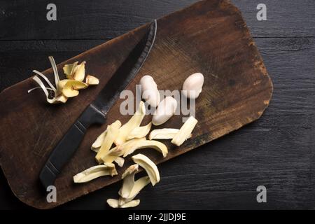 pezzi di carne di jackfruit e semi su un tagliere, con un coltello, frutta benefica per la salute tropicale originaria del sud-est asiatico, preso dall'alto Foto Stock