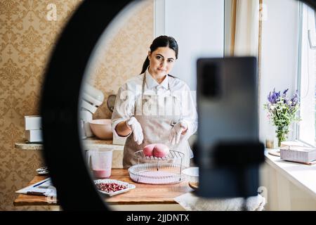 Side Hustle Ideas to Make Money, cucina online corsi. Asian Arabic donna pasticceria chef Foto Stock