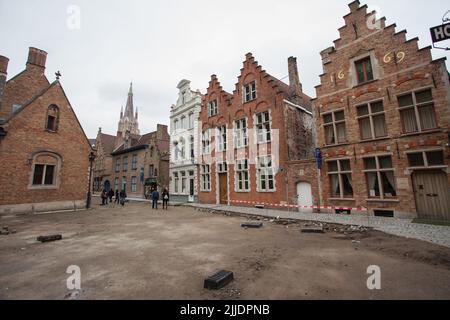 Bruges, Belgio, città strada scena, cantiere - piazza di ricostruzione in corso, con i circostanti edifici in vecchio stile gotico Foto Stock