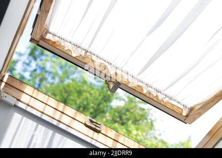 Moderno lucernario aperto (finestra sul tetto o finestra mansarda) in soffitta casa Foto Stock