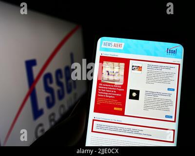 Persona che tiene il cellulare con il sito web della società di media indiana Essel Group sullo schermo di fronte al logo. Concentrarsi sul centro del display del telefono. Foto Stock