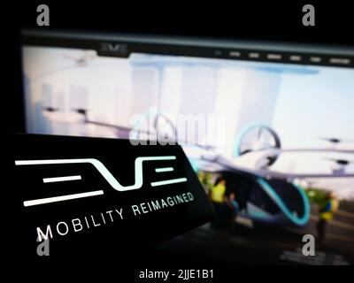 Telefono cellulare con il logo della società Eve Holding Inc. (Eve Air Mobility) sullo schermo di fronte al sito Web aziendale. Mettere a fuoco sulla sinistra del display del telefono. Foto Stock