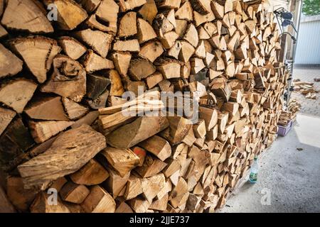 25 luglio 2022, Hessen, Francoforte sul meno: Legna da ardere appena consegnata è accatastata in un garage che appartiene ad una casa di fila. Foto: Frank Rumpenhorst/dpa Foto Stock