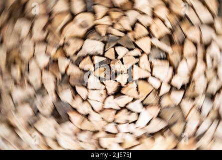 25 luglio 2022, Hessen, Francoforte sul meno: Legna da ardere appena consegnata è accatastata in un garage appartenente ad una casa a file (sparata con effetto rotante). Foto: Frank Rumpenhorst/dpa Foto Stock