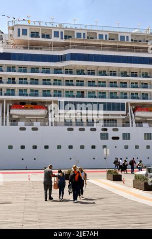 Pireo, Atene, Grecia - Maggio 2022: Persone che camminano dal terminal delle navi da crociera per salire a bordo della loro nave da crociera all'inizio della loro vacanza Foto Stock