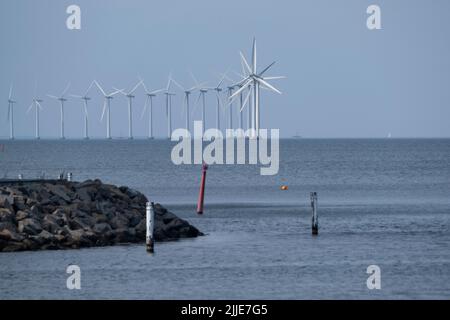 Copenaghen/DANIMARCA - 22 LUGLIO 2022: Alte turbine eoliche bianche in mezzo all'arcipelago danese, contro un cielo blu brillante Foto Stock