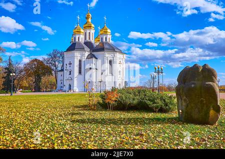 Il bellissimo parco autunnale con foglie cadute sull'erba di fronte al magnifico edificio barocco ucraino chiesa di Santa Caterina, Chernihiv, Ukra Foto Stock