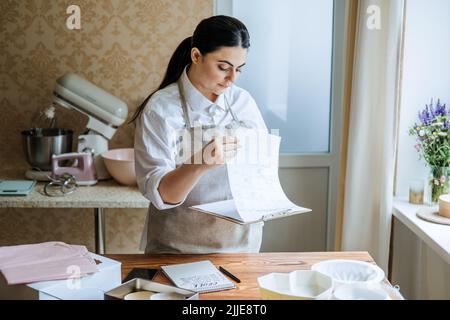 Piccolo imprenditore locale di pasticceria, pasticceria, pasticceria. Asian Arabic donna pasticceria chef Foto Stock