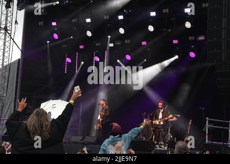 Irvine, Ayrshire, Scozia, Regno Unito. Il primo concerto inaugral che si tiene a Irvine Beach Park. I Twin Atlantic sono una band rock alternativa scozzese di Glasgow. Immagini foto scattate dalla folla. Donna sulle spalle di un uomo che guarda verso il palco Foto Stock