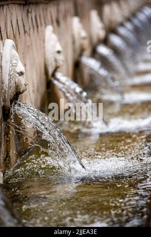 leoni maschera spruzzi d'acqua e fontane in un giardino formale sull'isola di creta in grecia, caratteristiche d'acqua in giardino, teste di leoni in pietra in giardino Foto Stock