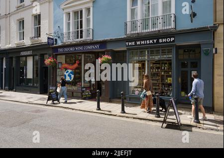 Persone che passeggiano accanto alla Oxford Wine Company e al Whisky Shop in Turl Street, Oxford, Regno Unito Foto Stock