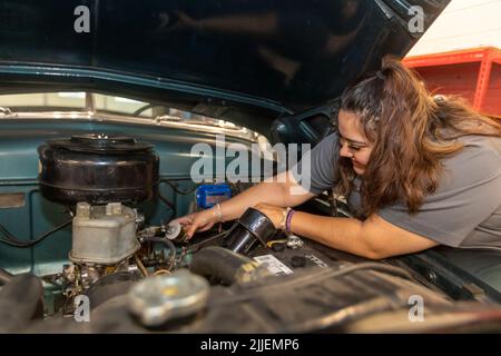 Aurora, Colorado - Cinthia Cabral sostituisce il filtro carburante di un'auto nelle mani del Carpenter. Il senza scopo di lucro ripara i veicoli appartenenti alle madri single a Foto Stock