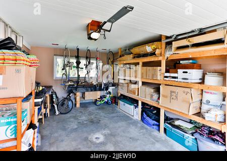 Squamish, Columbia Britannica, Canada - 2 aprile 2016: Un deposito interno organizzato del garage della casa riempito con roba personale e roba di rifiuto accatastato sugli scaffali. Foto Stock