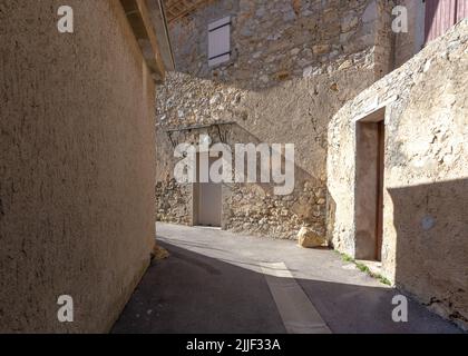 Vecchia strada del villaggio di Gruissan, Francia meridionale, con pareti in pietra e beige, preso in un soleggiato pomeriggio invernale senza gente Foto Stock