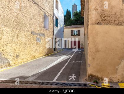 Vecchia strada del villaggio di Gruissan, Francia meridionale, con pareti in pietra e beige, preso in un soleggiato pomeriggio invernale senza gente Foto Stock
