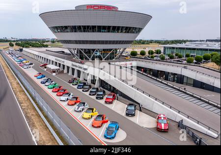 PRODUZIONE - 21 luglio 2022, Sassonia, Lipsia: L'ex Centro clienti e l'attuale Centro esperienze a forma di diamante domina la vista dello stabilimento Porsche di Lipsia. Porsche è iniziata qui nel 2002 con 300 dipendenti. A quel tempo, era ancora stato progettato come un semplice impianto di assemblaggio per la produzione del grande SUV Cayenne. Nel frattempo, Lipsia si è sviluppata in uno stabilimento completo con oltre 4300 dipendenti. Oltre all'e-Macan, che sarà in produzione in serie a Lipsia nel from2023, in Sassonia verrà costruito un nuovo SUV di grandi dimensioni con azionamento elettrico. (Vista aerea con drone) P. Foto Stock