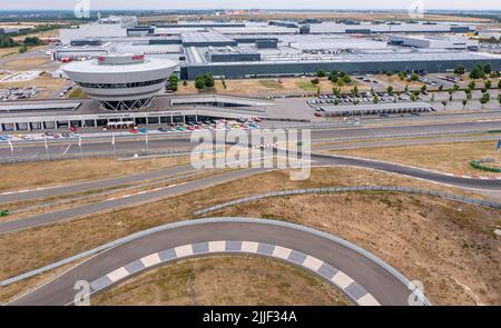 PRODUZIONE - 21 luglio 2022, Sassonia, Lipsia: L'ex Centro clienti e l'attuale Centro esperienze a forma di diamante domina la vista dello stabilimento Porsche di Lipsia. Porsche è iniziata qui nel 2002 con 300 dipendenti. A quel tempo, era ancora stato progettato come un semplice impianto di assemblaggio per la produzione del grande SUV Cayenne. Nel frattempo, Lipsia si è sviluppata in uno stabilimento completo con oltre 4300 dipendenti. Oltre all'e-Macan, che sarà in produzione in serie a Lipsia nel from2023, in Sassonia verrà costruito un nuovo SUV di grandi dimensioni con azionamento elettrico. (Vista aerea con drone) P. Foto Stock