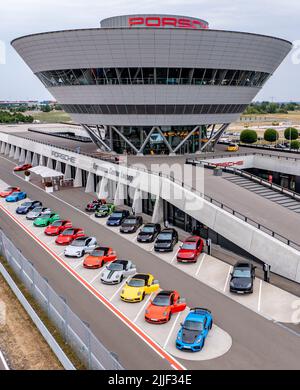 PRODUZIONE - 21 luglio 2022, Sassonia, Lipsia: L'ex Centro clienti e l'attuale Centro esperienze a forma di diamante domina la vista dello stabilimento Porsche di Lipsia. Porsche è iniziata qui nel 2002 con 300 dipendenti. A quel tempo, era ancora stato progettato come un semplice impianto di assemblaggio per la produzione del grande SUV Cayenne. Nel frattempo, Lipsia si è sviluppata in uno stabilimento completo con oltre 4300 dipendenti. Oltre all'e-Macan, che sarà in produzione in serie a Lipsia nel from2023, in Sassonia verrà costruito un nuovo SUV di grandi dimensioni con azionamento elettrico. (Vista aerea con drone) P. Foto Stock