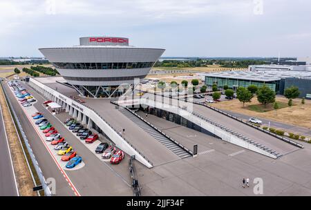 PRODUZIONE - 21 luglio 2022, Sassonia, Lipsia: L'ex Centro clienti e l'attuale Centro esperienze a forma di diamante domina la vista dello stabilimento Porsche di Lipsia. Porsche è iniziata qui nel 2002 con 300 dipendenti. A quel tempo, era ancora stato progettato come un semplice impianto di assemblaggio per la produzione del grande SUV Cayenne. Nel frattempo, Lipsia si è sviluppata in uno stabilimento completo con oltre 4300 dipendenti. Oltre all'e-Macan, che sarà in produzione in serie a Lipsia nel from2023, in Sassonia verrà costruito un nuovo SUV di grandi dimensioni con azionamento elettrico. (Vista aerea con drone) P. Foto Stock