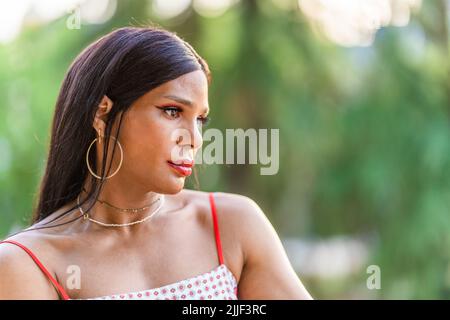 Donna transgender che guarda da parte con espressione preoccupata all'aperto Foto Stock