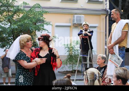 Odessa, Ucraina. 23rd luglio 2022. Il pubblico guarda come attori teatrali eseguire 'Odessa, io ti amo' al mercato del libro a Odessa. Lo spettacolo 'Odessa, ti amo' racconta storie della vita degli abitanti di Odessa con il suo caratteristico colore e umorismo. Lo spettacolo è stato organizzato dagli attori del Teatro n° 7 e giocato all'aperto al mercato del libro. L'obiettivo della performance è quello di raccogliere donazioni per esigenze di difesa aerea (Photo by Viacheslav Onyshchenko/SOPA Images/Sipa USA) Credit: Sipa USA/Alamy Live News Foto Stock