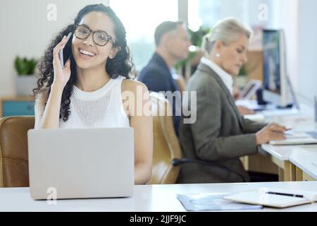 Una giovane donna d'affari in una chiamata in ufficio al lavoro. Foto Stock