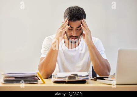 Non so come mi capita di superare questo problema: Un bel giovane seduto da solo e che si sente stressato mentre lavora da casa. Foto Stock