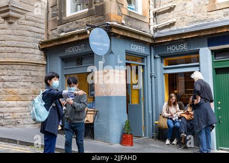 Hideout caffè caffetteria nella parte superiore dell'arco, la gente aspetta caffè, maschere a causa di covid 19, città vecchia di Edimburgo, Scozia, Regno Unito estate 2022 Foto Stock