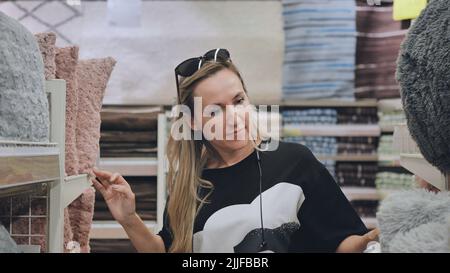 La ragazza nel deposito sta scegliendo i cuscini per la casa. Foto Stock