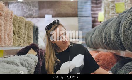 La ragazza nel deposito sta scegliendo i cuscini per la casa. Foto Stock