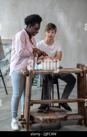 Un ragazzo che fa una pentola in uno studio d'arte Foto Stock