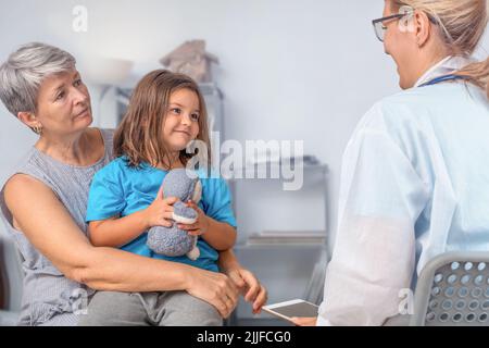 Un bambino con un anziano ad un appuntamento dell'ufficio del medico Foto Stock