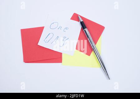 Nota adesiva vuota con clip per lavanderia pila di pennarelli colorati posizionati sul tavolo. Foto Stock