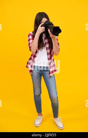 Fotografo ragazza adolescente con una fotocamera reflex digitale. Fotocamera digitale per bambini. Bambino che fotografa. Scuola di fotografia. Bambino fotografo principiante. Foto Stock